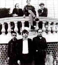 black and white photograph of four people standing on a balcony