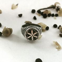 Hand carved and cast in solid sterling silver. The Hexafoil sits atop this signet ring with texturing on the top and sides.  The hexafoil has a long history as a ritual protection mark. It dates back to the Bronze Age, where it was used at ancient burial sites. During the Roman period, it was often seen carved on altar stones. The hexafoil is a symbol of purity often associated with the Trinity. Anglo-Saxons and Normans used it on baptismal fonts to safeguard the spiritually vulnerable. The symb Hex Signs, Flower Texture, Pennsylvania Dutch, The Trinity, Textured Ring, Anglo Saxon, Long History, Bronze Age, Delicate Details