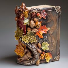 an intricately decorated book with autumn leaves and acorns