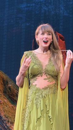 a woman in a yellow dress holding a string with her mouth open and tongue out