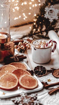 a table topped with cookies and candles next to a christmas tree