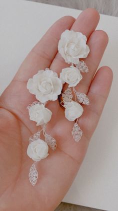 a hand holding some white flowers on it