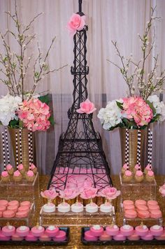 the eiffel tower is decorated with pink flowers and cupcakes for dessert