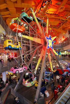 a ferris wheel in the middle of a mall filled with lots of people and cars