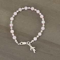 💜Pink rose quartz beads alternate with small hot pink seed beads and sterling silver spacer beads. 💜Sterling silver lobster claw clasp. 💜Small sterling  silver angel charm. 💜Pink and silver in color. 💜8 in/20.32 cm in length. 💜Rose Quartz is connected to the upper 4 chakras. Promotes compassion, forgiveness, and calm. Helps clear stored anger and resentment. 💜Link below to view all bracelets in my shop. https://www.etsy.com/shop/HisHandsJewerly?section_id=35856291 💜This bracelet comes with a purple velvet protective pouch. Adjustable Pink Beaded Bracelet With Silver Beads, Silver Rosary Bracelet With Gemstone Beads, Silver Rose Quartz Bracelet With 8mm Beads, Silver Rosary Bracelet With Gemstone Beads As Gift, Silver Beaded Rose Quartz Bracelets, Pink Charm Bracelet With Silver Beads, Ideal For Gifting, Adjustable Silver Rosary Bracelet With Gemstone Beads, Pink Charm Bracelet With Silver Beads As A Gift, Silver Crystal Bracelet With Rose Quartz Round Beads