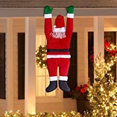 an inflatable santa clause hanging from a porch