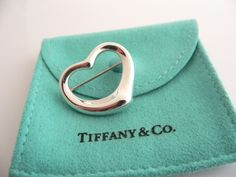 Overview:Offered for sale is a wonderful Tiffany and Co. Silver Peretti Open Heart Brooch/Pin.   The piece is made from substantial Tiffany silver formed into Peretti's classic Open Heart Heart shape.  In very good condition, this piece is one that you will turn to very often to jazz up your wardrobe.  It is no longer produced, and thus makes a great addition for any Tiffany collector.   The piece has a perfectly working locking mechanism, and is fully hallmarked.Everyone needs a Signature Ti Elegant Silver Heart-shaped Brooch, Elegant Silver Heart-shaped Brooches, Elegant Silver Heart Brooch, Elegant Silver Heart Brooches, Elegant Heart-shaped Wedding Brooch, Classic Love, Rare Gifts, Heart Pin, Breakfast At Tiffany's