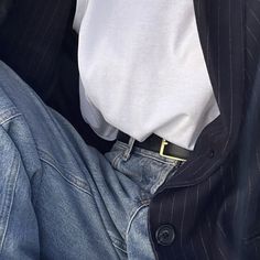 a man in a suit and tie with his hands on his hips, sitting down