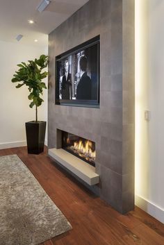 a living room with a tv mounted on the wall and a fire place in front of it