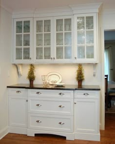 a kitchen with white cabinets and black counter tops