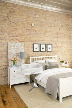 a bedroom with brick walls and white furniture