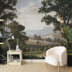 a living room with a painting on the wall and a white chair in front of it