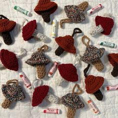 many crocheted hats are arranged on a white tablecloth with toothbrushes