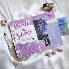 an open book with writing on it next to some other items that are laying on the bed