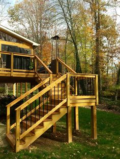 a wooden deck with stairs leading up to a house