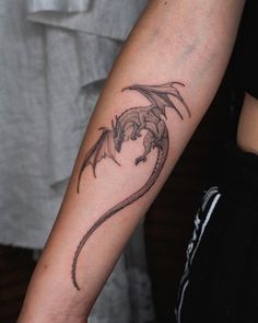 a small dragon tattoo on the arm