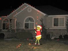 a christmas light display in front of a house with santa clause on it's head