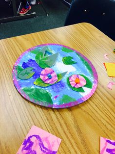 the paper plate has flowers on it and is next to cut out pieces of paper