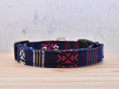 a blue dog collar with red, yellow and green designs on it's side