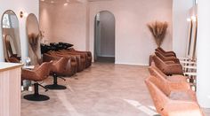 a hair salon with brown chairs and mirrors