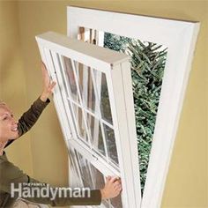 a woman is opening the window with her hands