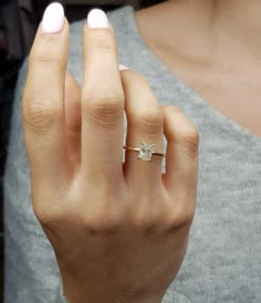 a woman's hand with a diamond ring on it