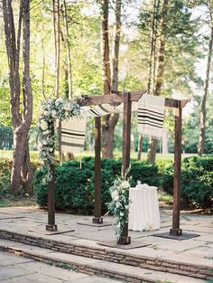 an outdoor ceremony setup with white flowers and greenery