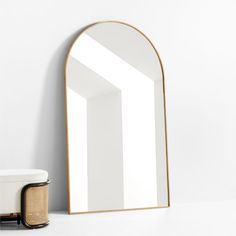 a mirror sitting on top of a table next to a stool