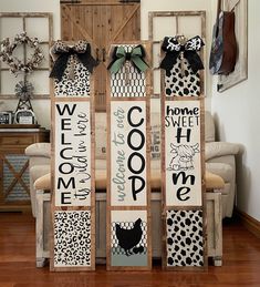 two wooden signs with black and white designs on them sitting in front of a couch