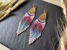 Statement earrings with long ombre fringes and detailed brass findings Color: brass with pink to light blue color gradient These large fringe earrings stand out immediately because of their finely worked brass findings and long ombre fringes. The color gradient is an irregular pattern which results in a more natural looking color transition and less like a structured color scheme. In addition differently colored beads were used to add more details to the fringe - either as little dots, embellish Pink Handwoven Beaded Drop Earrings, Bohemian Pink Tassel Earrings With Beaded Fringe, Handmade Pink Tassel Earrings For Festival, Pink Handmade Tassel Earrings For Festivals, Pink Handwoven Drop Earrings, Handwoven Pink Drop Earrings, Pink Fringe Earrings For Festival, Pink Handwoven Dangle Earrings, Handmade Pink Chandelier Earrings For Festivals