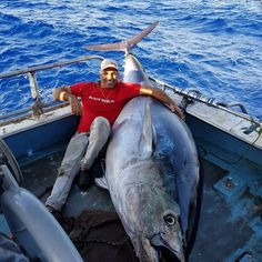 a man sitting on the back of a boat with a big fish