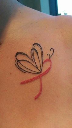 a small tattoo on the back of a woman's upper body, depicting a butterfly