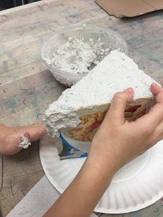 a person is holding a piece of cake on a paper plate