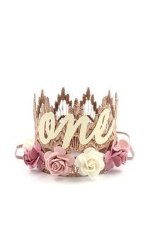 a tiara with the word grace written on it and flowers in front of it