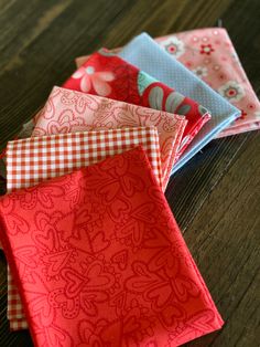 four folded napkins sitting on top of a wooden table