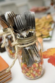 a jar filled with lots of silverware sitting on top of a table