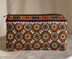 "Small Silk Petit Point Clutch, Handbag Organizer, Make Up Organizer created and handmade in Uzbekistan. Lined with silk and cotton fabric, zipper top.  Each clutch is hand drawn on to cotton canvas, inspired by original designs from Uzbekistan history.  Measures 5.5\"  high x 9\" width, 8\" opening  Embroidery the same on the front and the back of the clutch Can fit largest sizes of iPhone and Android. 100% silk petit point with handwoven silk and cotton lining. Your purchase preserves and enco Artisan Multicolor Clutch As A Gift, Artisan Multicolor Rectangular Clutch, Handmade Multicolor Coin Purse For Travel, Traditional Multicolor Bag With Zipper Pouch, Traditional Multicolor Zipper Pouch Bag, Bohemian Handmade Multicolor Coin Purse, Handmade Multicolor Bohemian Coin Purse, Bohemian Multicolor Handmade Coin Purse, Traditional Multicolor Pouch Coin Purse