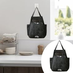 a black bag hanging from the side of a kitchen counter next to plates and bowls