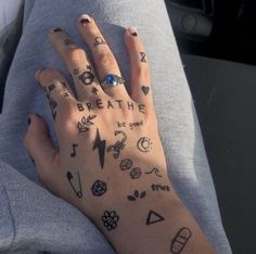 a person's hand with tattoos on it and the words breathe written all over them