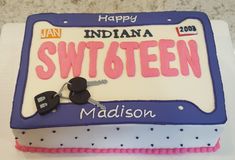 a birthday cake that has been decorated with the name and two car keys on it