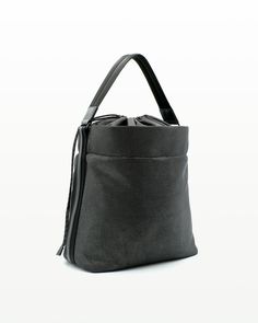 a gray bag with black handles and zippers on the front, sitting against a white background