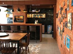 a restaurant with wooden tables and chairs next to a chalkboard wall covered in pictures