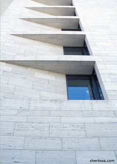 the side of a tall building with windows