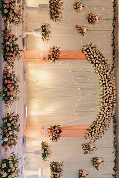 an overhead view of a wedding ceremony with flowers on the wall and lights in the background