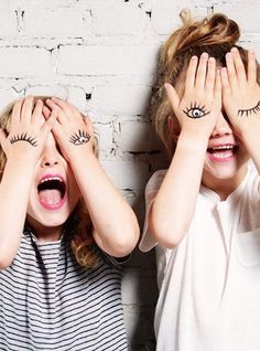 two children covering their eyes with fake eyelashes