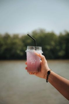 a person holding a cup with a straw in it