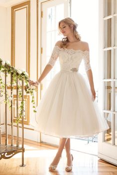 a woman in a white dress is standing on the stairs