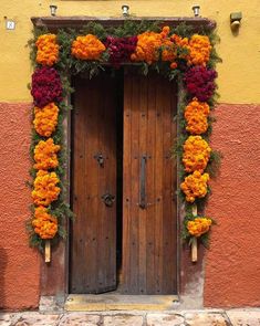 two wooden doors decorated with flowers and greenery