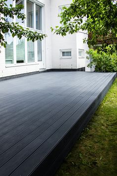 a large black deck in front of a white house