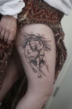 a woman's thigh with a tattoo of a horse and rider on the side